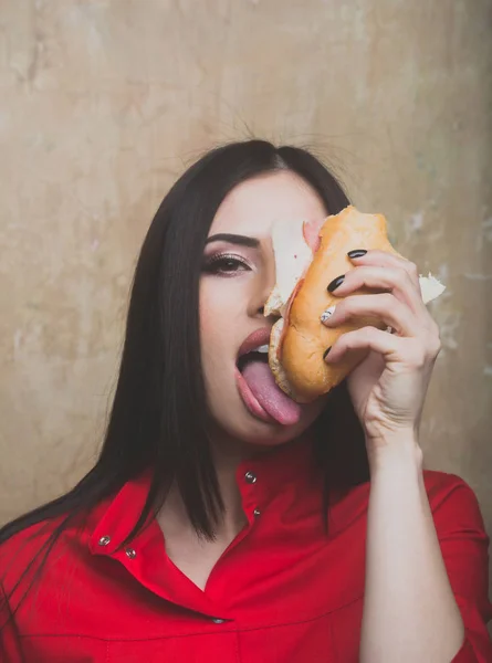 Голодна сексуальна красива брюнетка їсть великий бутерброд або бургер — стокове фото