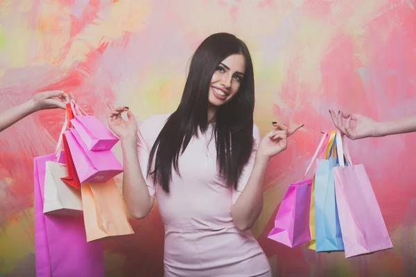 Pretty sexy smiling woman with shopping bags on colorful background — Stock Photo, Image