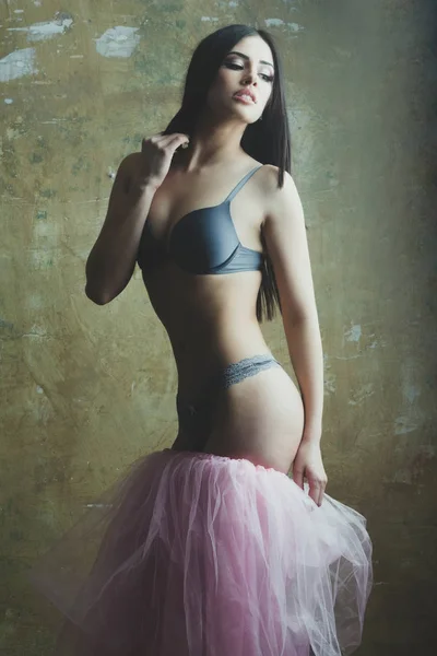 Ganska sexig kvinna i rosa kjol och behå på kroppen — Stockfoto