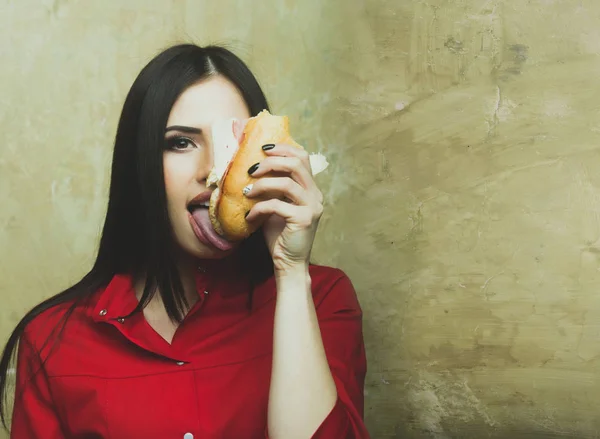 Hungry sexy pretty brunette woman eats big sandwich or burger — Stock Photo, Image