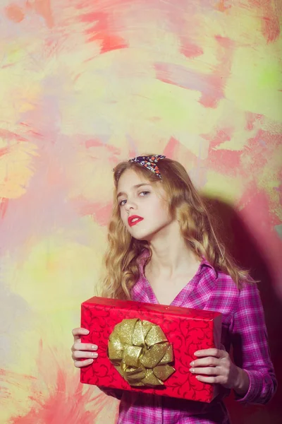 Linda chica con caja de regalo roja con lazo dorado — Foto de Stock