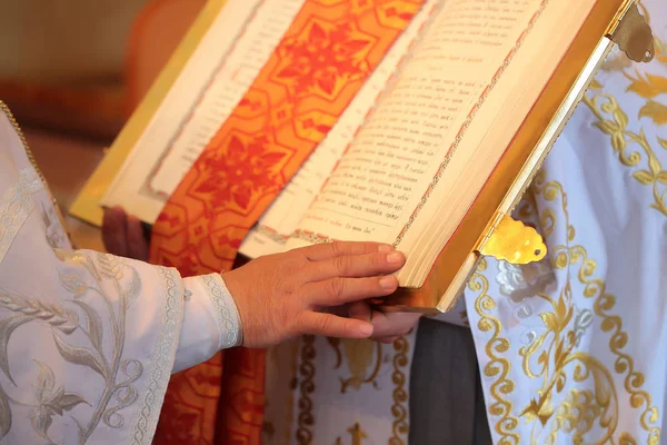 Priest hand on open bible — Stock Photo, Image