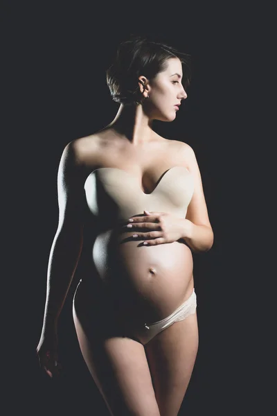 Bella donna incinta con pancia rotonda isolato su nero — Foto Stock