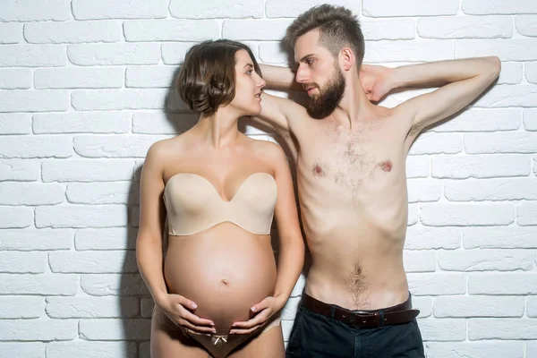 Homem magro barbudo e mulher grávida bonita com barriga redonda — Fotografia de Stock