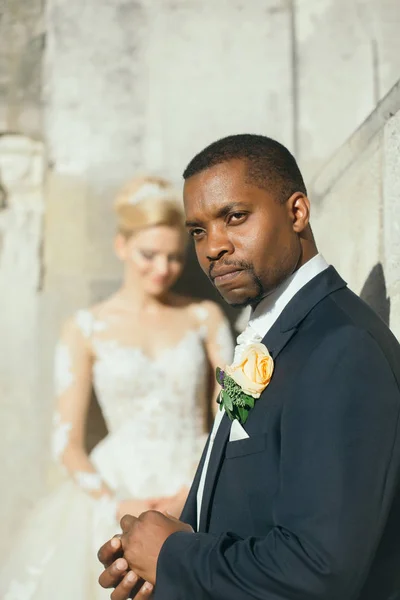 Handsome bearded african American groom touches wedding ring on finger