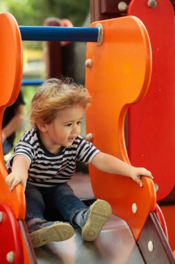 Şirin mutlu bebek çocuk turuncu slayt tahta at binme