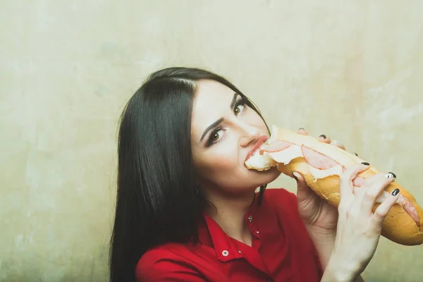 Sexig brunett kvinna äter stora smörgås eller burger — Stockfoto