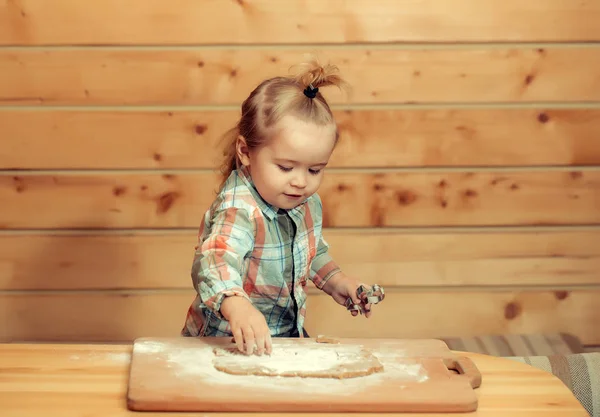 Carino bambino cucina con pasta e farina, tiene stampo metallico — Foto Stock