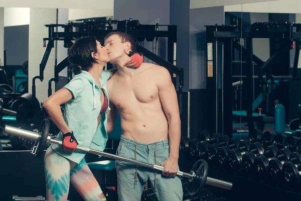 Muskularny mężczyzna i dziewczyna w siłowni z całowanie z Brzana — Zdjęcie stockowe