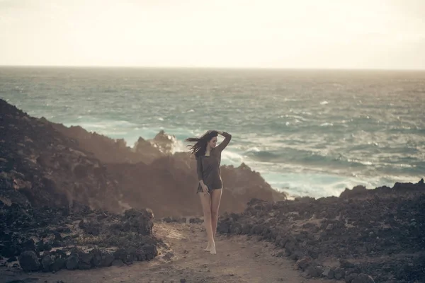 漂亮的女孩站在石滩上 — 图库照片