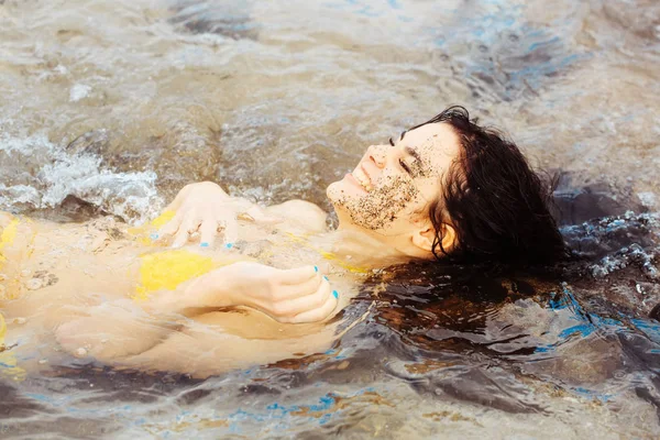 바다에 누워 섹시 한 노란색 수영복에 아주 행복 한 여자 — 스톡 사진