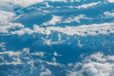 Pastoral karlı dağ zirveleri bulutlar düzlem altında