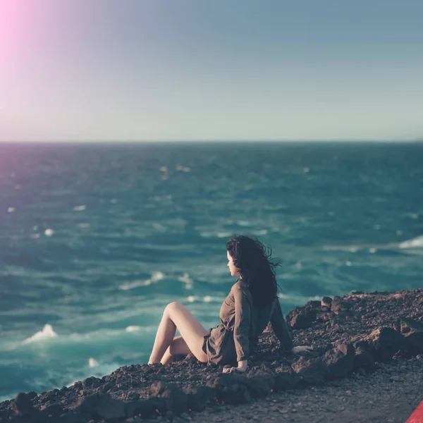 漂亮的女孩坐在山坡波浪的海面上 — 图库照片
