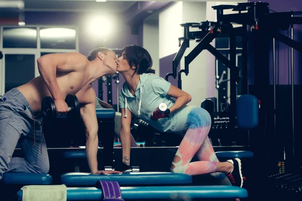 Musculoso hombre y chica en el gimnasio con mancuernas — Foto de Stock