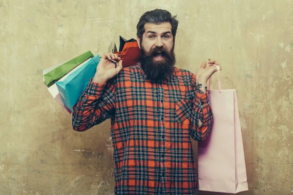 Hombre barbudo feliz sosteniendo coloridas bolsas de papel — Foto de Stock