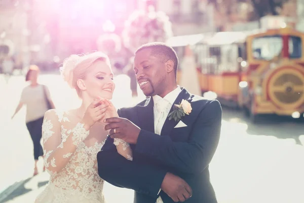 Happy african American groom and cute bride walking on street — Stock Photo, Image