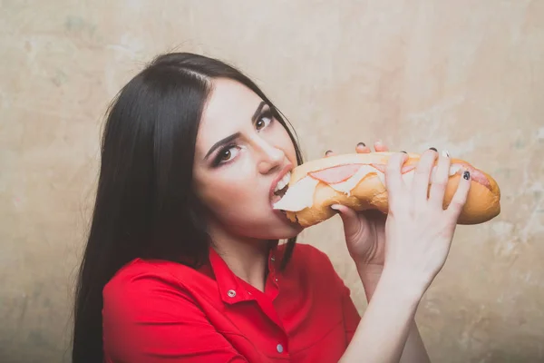 Seksi güzel esmer kadın büyük sandviç ya da hamburger yiyor — Stok fotoğraf