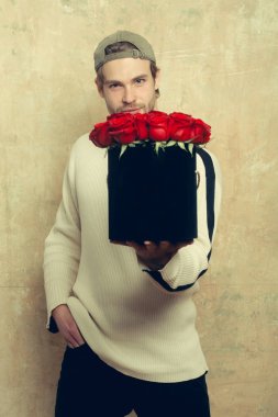 sakallı adam tutar kırmızı gül kutusu dokulu duvar