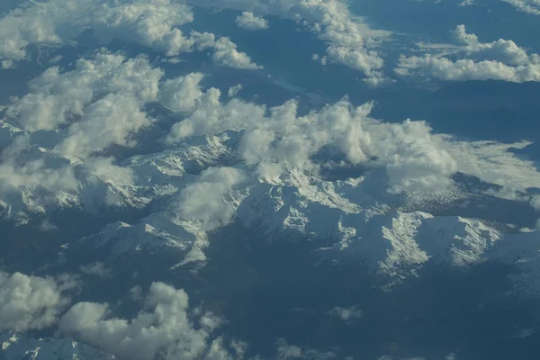 Idylliczne ośnieżonych górskich szczytów pod chmurami od płaszczyzny — Zdjęcie stockowe