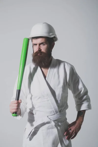 Bearded karate man in kimono, helmet with baseball bat — Stock Photo, Image