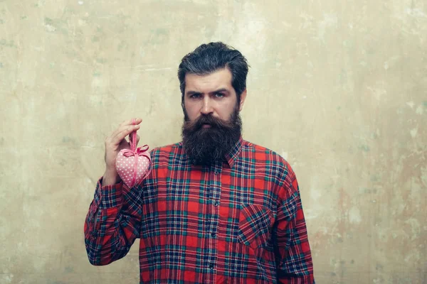Gelukkig bebaarde man met baard houdt rooskleurig textiel hart — Stockfoto