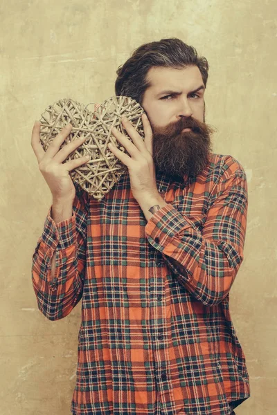 Homem barbudo com barba longa mantém o coração de vime — Fotografia de Stock