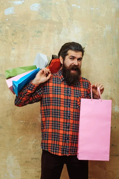 Happy bebaarde man met kleurrijke papieren draagtassen — Stockfoto