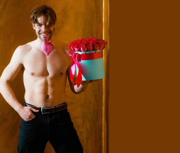 セクシーな体にひげを生やした筋肉男を保持する赤いローズ ボックス — ストック写真