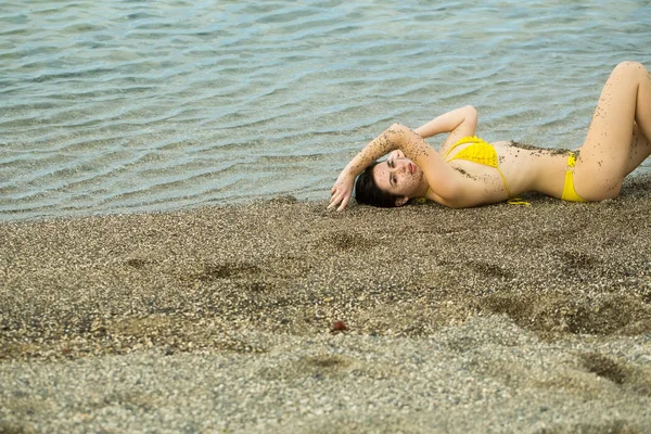 Linda chica en traje de baño amarillo durmiendo en la playa de mar —  Fotos de Stock