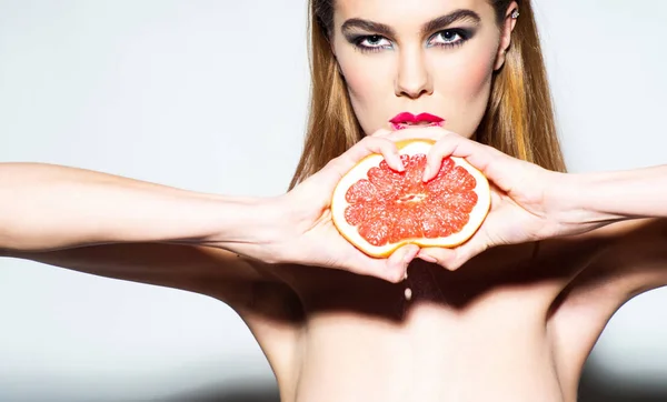 Söt flicka klämma juice från färsk apelsin grapefrukt — Stockfoto