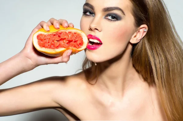 Söt flicka klämma juice från färsk apelsin grapefrukt — Stockfoto