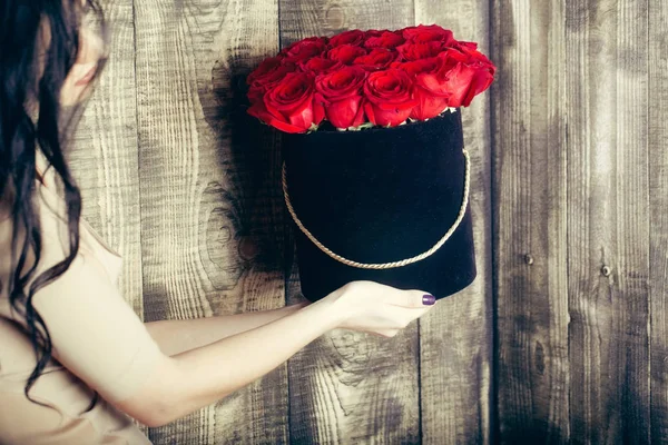 Prachtige rode rozen in de zwarte doos in de handen van meisje — Stockfoto