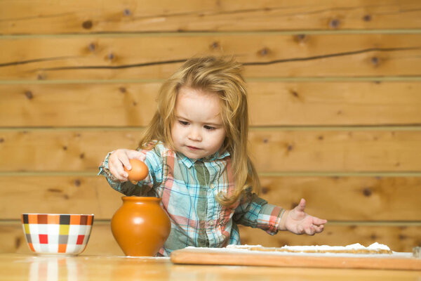 cute child cooking with dough, flour, egg and bowl