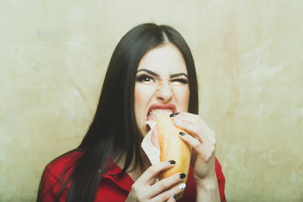 Sexig brunett aggressiv kvinna äter stora smörgås eller burger — Stockfoto