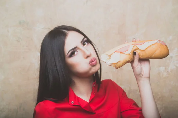 Сексуальная красивая брюнетка ест большой сэндвич или бургер — стоковое фото