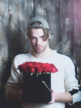 adam tutar kırmızı gül çiçekler kutusunda sakallı