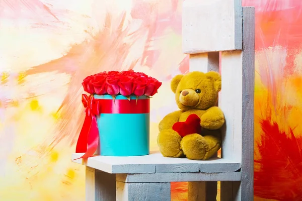 Red roses in box, shopping bags, heart and teddy bear — Stock Photo, Image