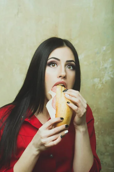 Сексуальна красива брюнетка налякана жінка їсть великий бутерброд або бургер — стокове фото