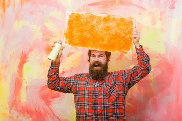 happy bearded man holding orange oil paint texture on canvas