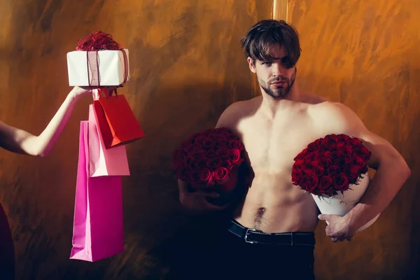 Brodaty mężczyzna mięśni, czerwona róża, kobiece ręką z obecnie — Zdjęcie stockowe