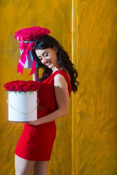 Ganska nöjd flicka leende med rosor i lådor — Stockfoto