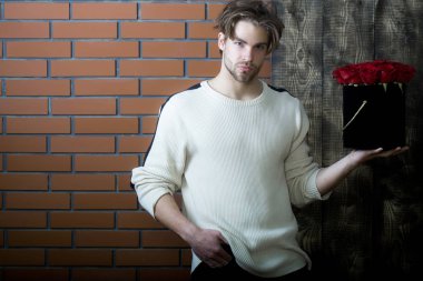 sakallı adam kutusunda mevcut olarak kırmızı gül çiçekler tutar