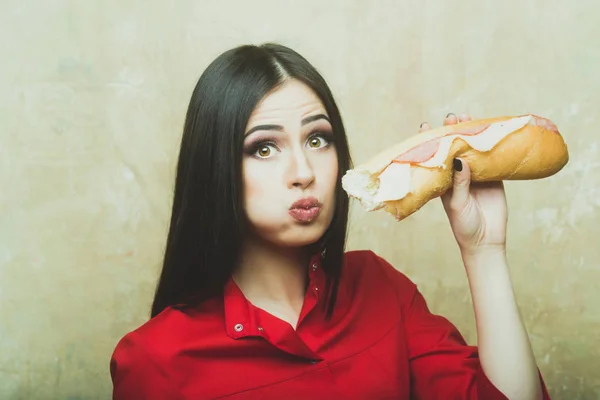 Sexy pretty brunette surprised woman eats big sandwich or burger — Stock Photo, Image