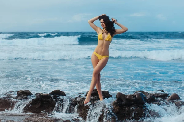 Гарненька дівчина в sexi жовтий купальник стоїть в білій піні — стокове фото