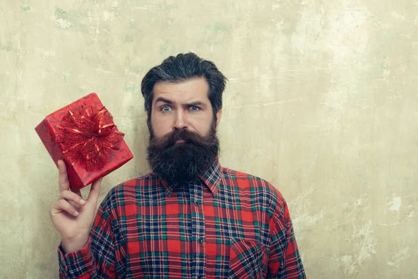 Hombre barbudo triste con caja de regalo roja con lazo —  Fotos de Stock
