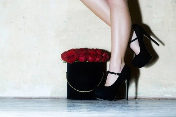 Piernas femeninas sexy con hermosas rosas rojas en la caja —  Fotos de Stock