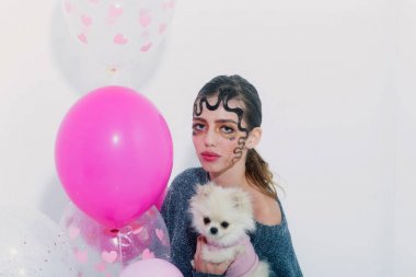 Pomeranian köpek ve Parti balonları ile güzel kız