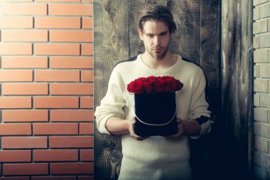 sakallı adam kutusunda mevcut olarak kırmızı gül çiçekler tutar