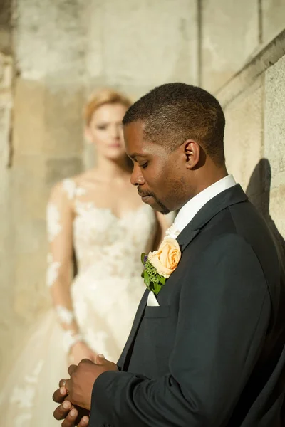 Handsome bearded african American groom touches wedding ring on finger