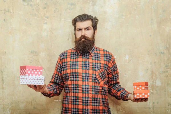 Ciddi sakallı adam renkli hediye kutuları tutarak ellerinde yığılmış — Stok fotoğraf